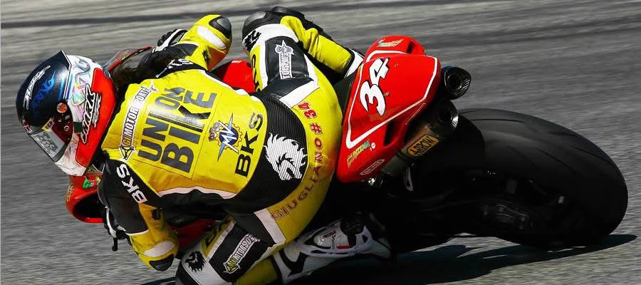 Pilota Unionbike in piega con il ginocchio a terra durante una gara